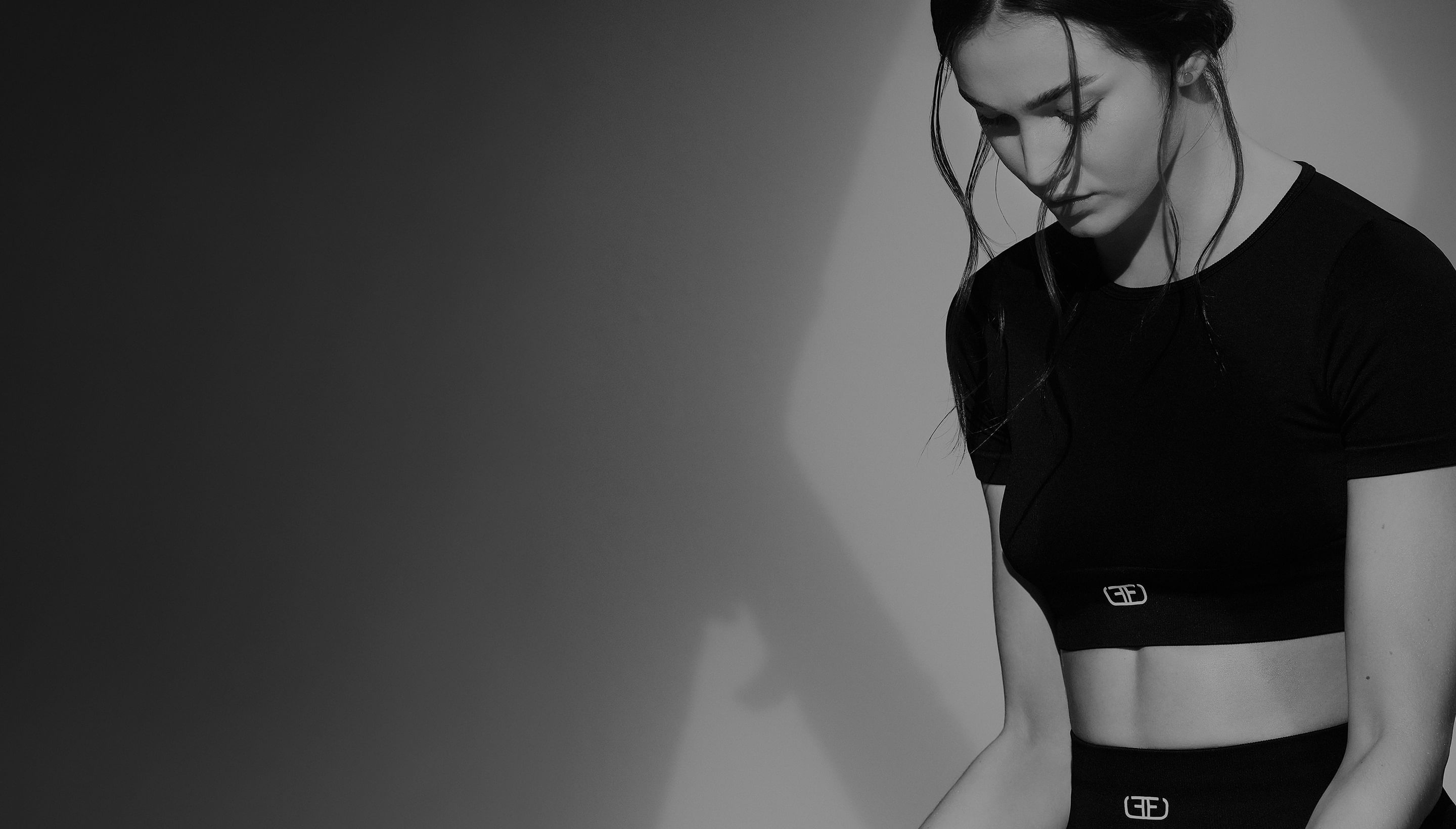 Modelo con crop top deportivo de mujer en color negro de la marca Studio F