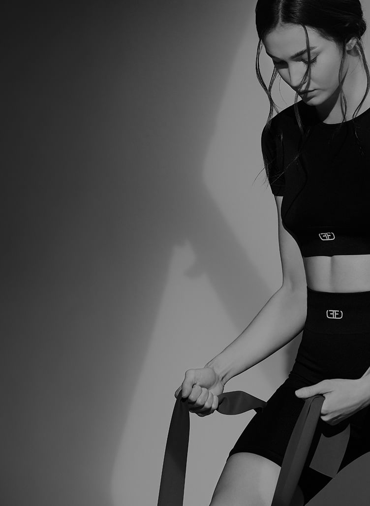 Modelo con crop top deportivo de mujer en color negro de la marca Studio F