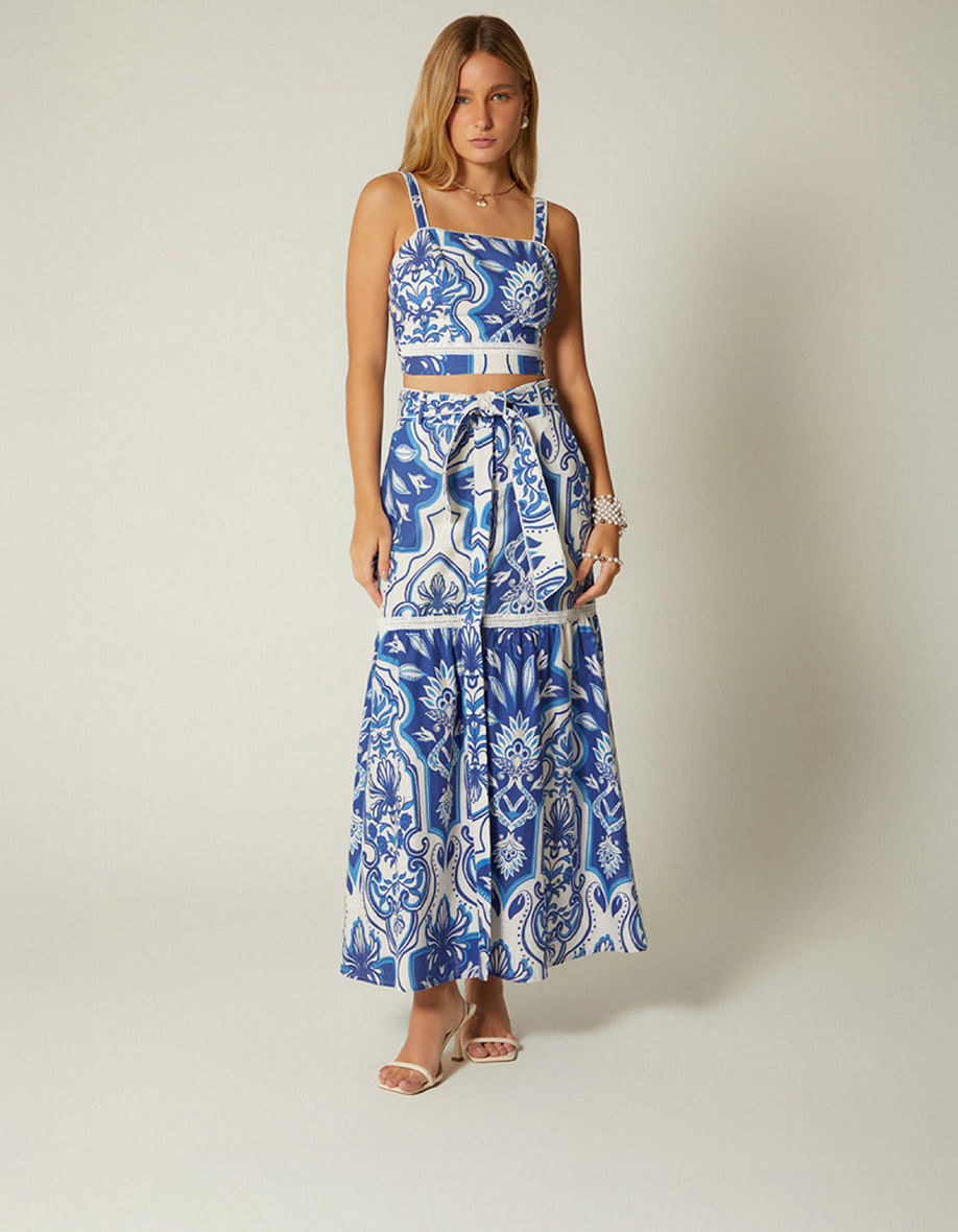Mujer luciendo vestido azul estampado  con bolso de mano