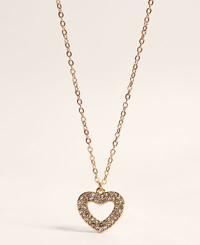 Collar dorado con dije de corazón brillante. Accesorio romántico para elevar un outfit de cita en San Valentín.