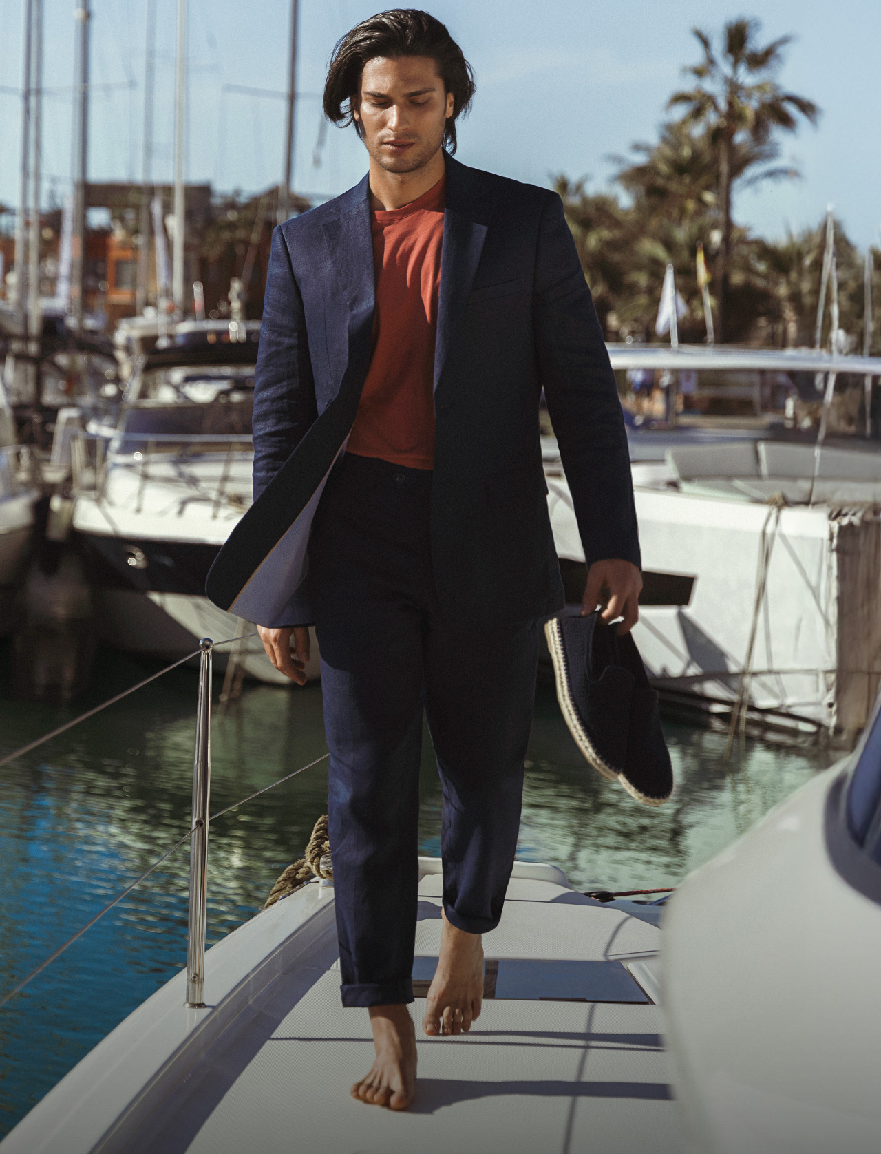 Hombre vistiendo look casual compuesto por: Pantalón y blazer en color azul oscuro, camiseta color terracota y zapatos casuales