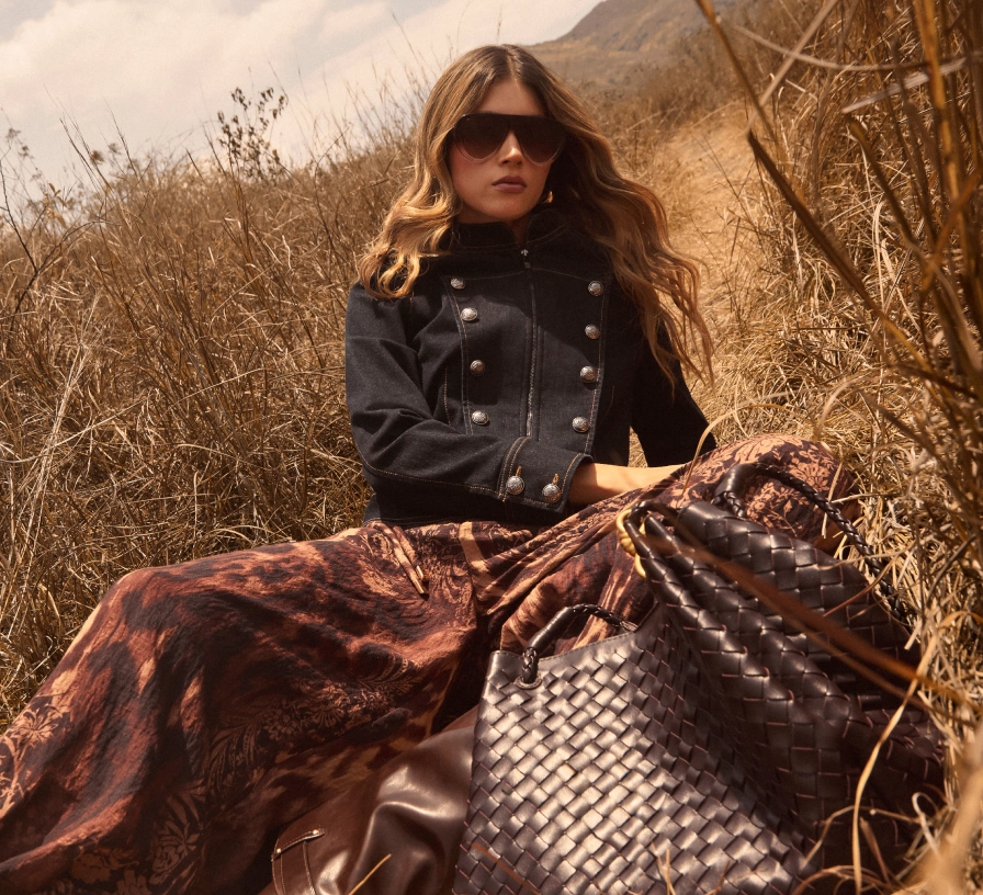 Mujer con chaqueta negra y falda larga estampada café de la colección Fall Studio F