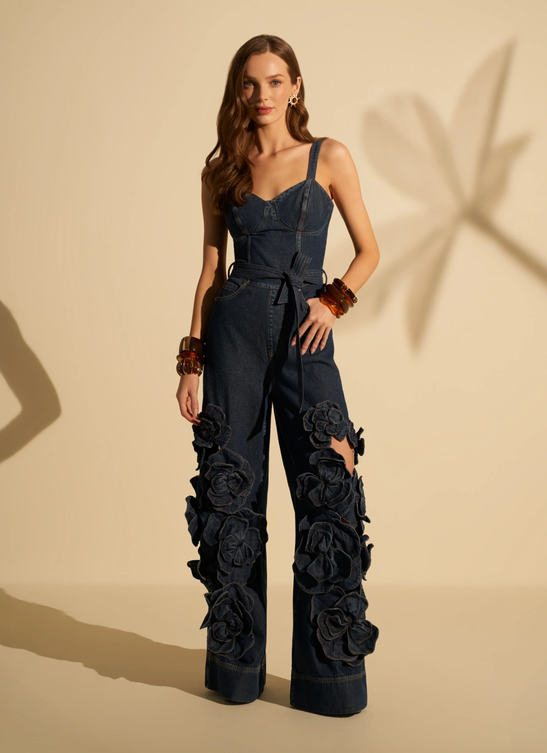 Mujer con enterizo denim de corset y pantalón con aplicaciones de flores tridimensionales.