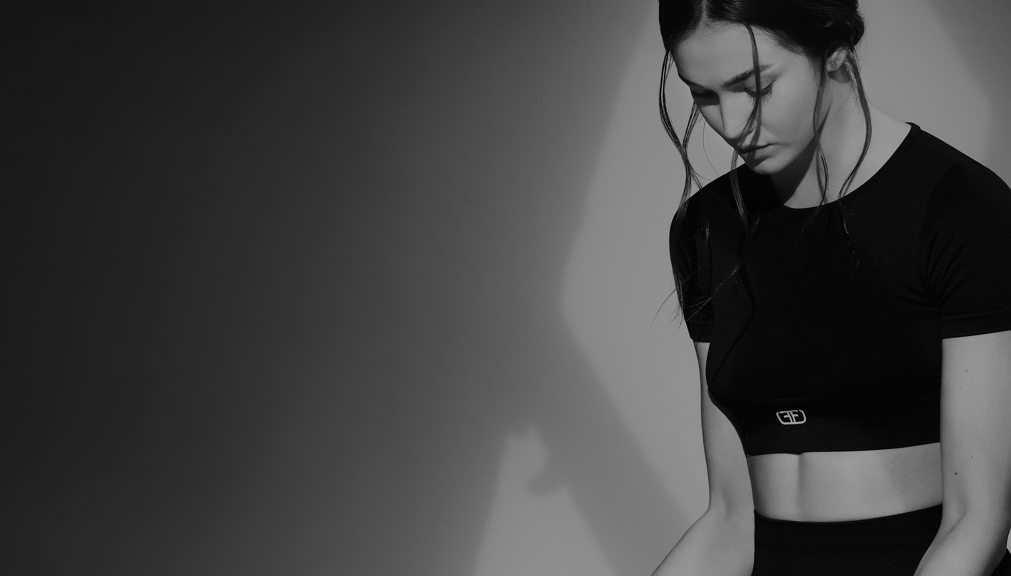 Modelo con crop top deportivo de mujer en color negro de la marca Studio F