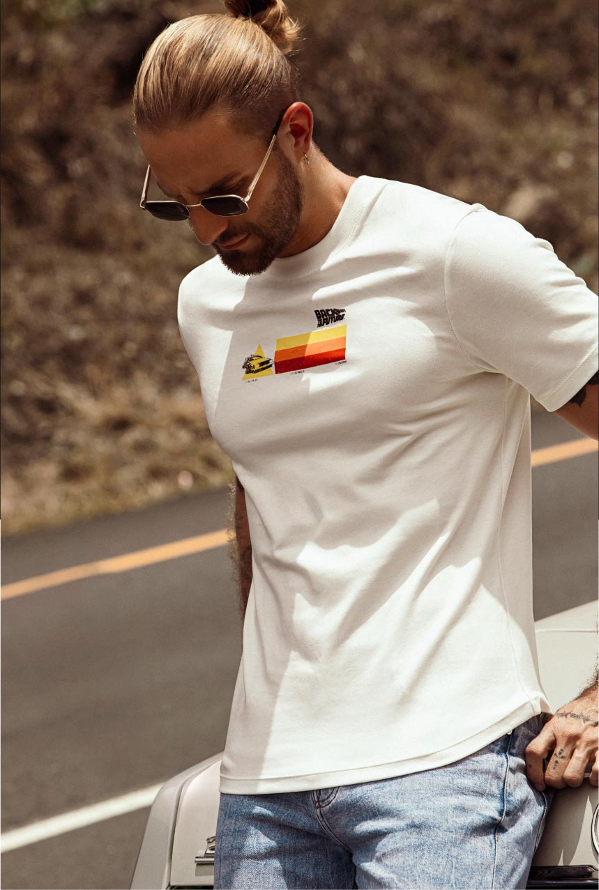 Hombre con camiseta blanca estampada y jean azul claro, look casual y juvenil STUDIO F MAN