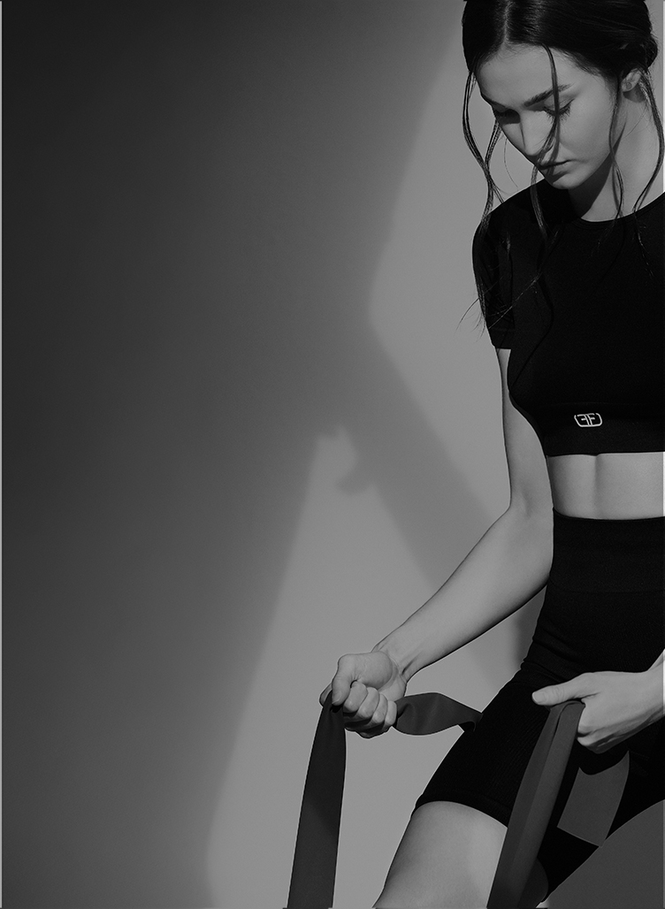 Modelo con crop top deportivo de mujer en color negro de la marca Studio F
